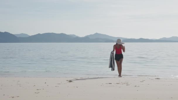 Mujer joven en sombrero de sol en la playa — Vídeo de stock