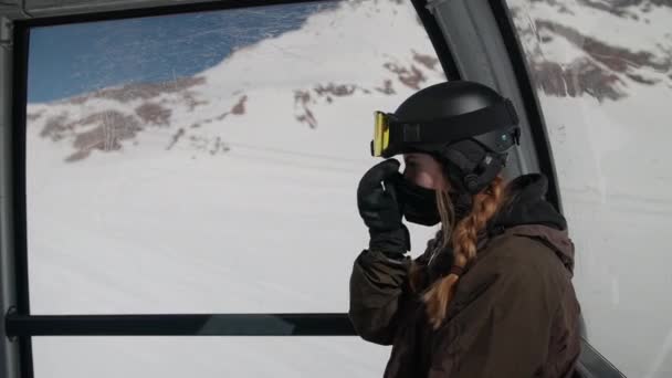 Žena v lyžařském oblečení uvedení na tvář masku a lyžařskou masku — Stock video