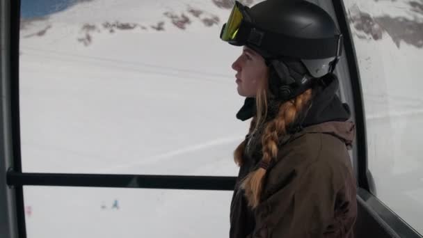 Frau in Skibekleidung legt Handy in Seilbahn weg — Stockvideo