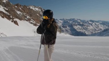 Woman Putting On Reflection Ski Visor On Ski Slope