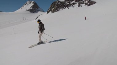 Dağ yamacında kayak yapan genç kadın.