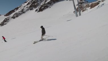 Dağ yamacında kayak yapan genç kadın.