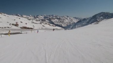 Ski Slope With Other Skiers In View And Mountains Beyond