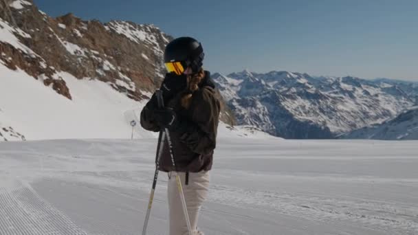 Vrouw zetten op reflectie Ski vizier op de skipiste — Stockvideo