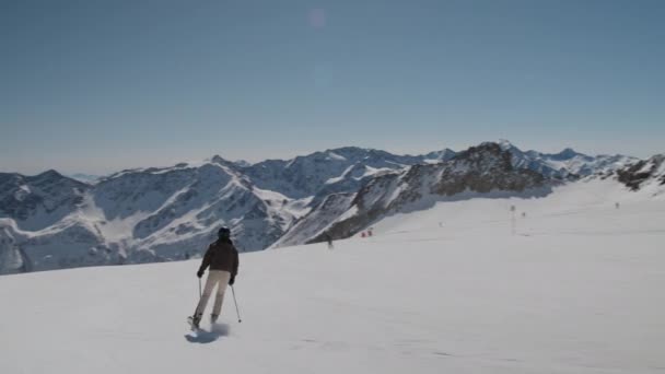 Ung kvinna skidåkning ner solig skidbacke — Stockvideo
