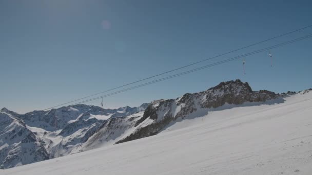 Лыжники на лыжном склоне с подъемниками — стоковое видео