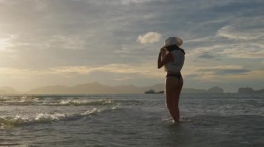 Tangalı Kadın ve Güneş Şapkalı Denizde Yürüyen Kadın