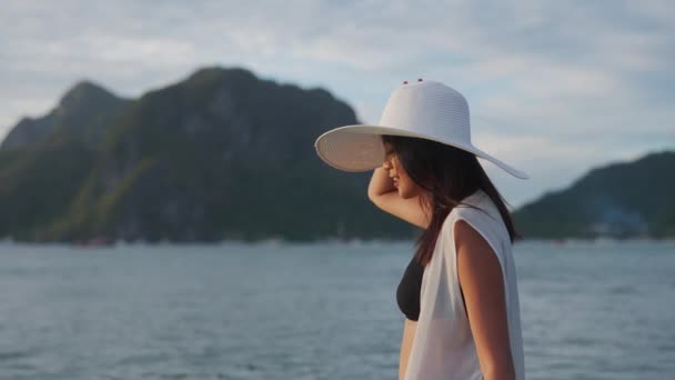 Mulher de biquíni e chapéu de sol andando no mar — Vídeo de Stock