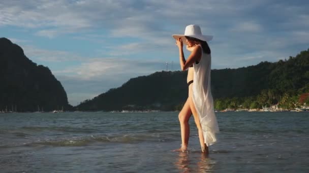 ビキニ姿の女と海を歩くサンハット — ストック動画