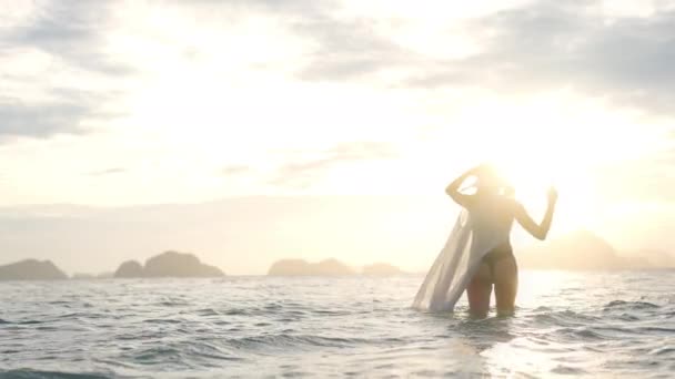 Woman In Thong And Sun Hat In Sea Towards Sunset — Vídeo de stock