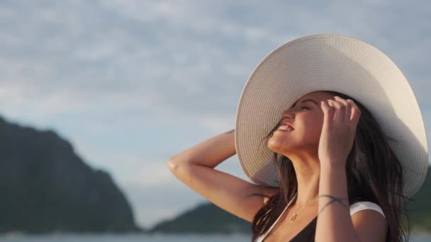Женщина в солнечной шляпе защищает глаза от яркого солнечного света — стоковое видео