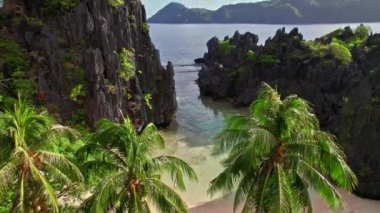 Uçurumlar ve saklanmış kumsalların palmiyeleriyle denizden gelen İHA.