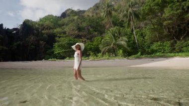 Woman In Sunhat Walking In Sea Of Hidden Beach