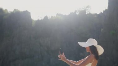 Woman Standing In Sea And Texting On Cell Phone