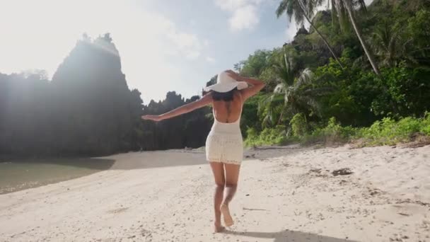 Žena běží podél a otáčí se k úsměvu na kameru na pláži — Stock video