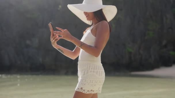 Mulher posando para smartphone como ela está em águas rasas — Vídeo de Stock
