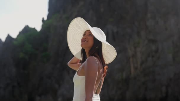 Vrouw in hoed kijken omhoog onder gloeiend zonlicht — Stockvideo