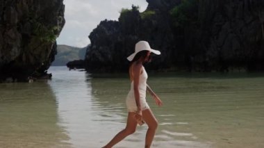 Young Woman In Sun Hat Kicking Tidewater On Hidden Beach