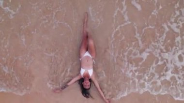 Woman In Bikini Lying In Shallow Tide On Nacpan Beach