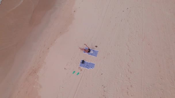 Kobieta siedzi na ręczniku na plaży Nacpan — Wideo stockowe