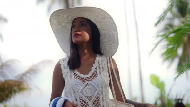 Νεαρή γυναίκα στον ήλιο καπέλο περπατώντας κατά μήκος στην παραλία Nacpan — Αρχείο Βίντεο