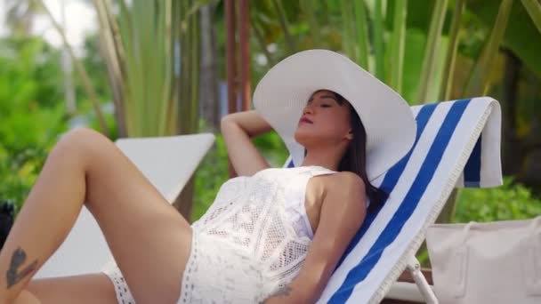 Woman Relaxing With Eyes Closed In Sun Hat On Sun Lounger — Vídeo de stock