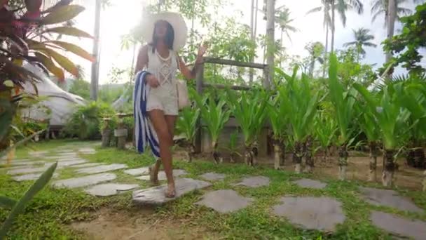 Woman In Sun Hat Walking With Beach Towel On Resort Path — Wideo stockowe