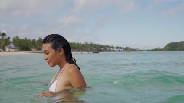 Γυναίκα με βρεγμένα μαλλιά στο μπικίνι στέκεται στη θάλασσα — Αρχείο Βίντεο