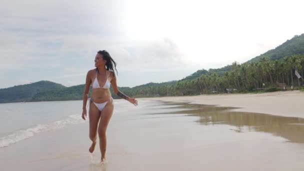 ビーチ沿いを走るビキニ姿の若い女 — ストック動画