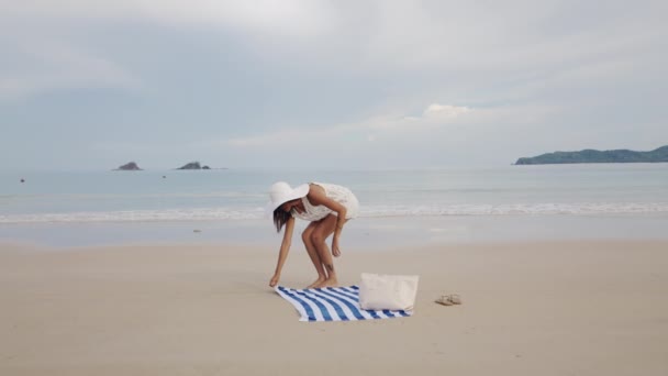 Жінка розставляє рушник, щоб сісти на пляжі Накпан — стокове відео