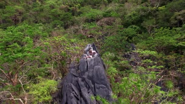 Kobieta trzyma szal w bryzie na szczycie wapiennych skał — Wideo stockowe
