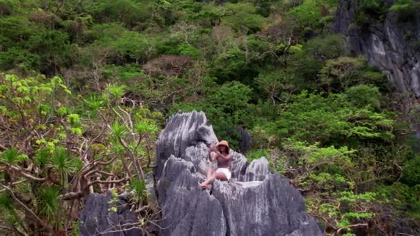 Drone Of Woman Sitting On Limestone Rocks Taking Selfie — 비디오