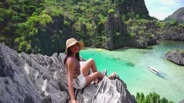 Woman In Sun Hat Sitting On Rocks Above Hidden Beach — Vídeo de stock