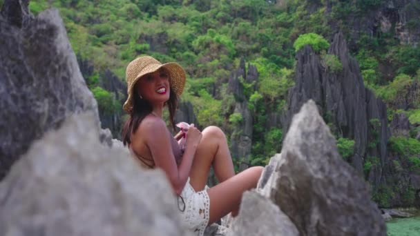 Uśmiechnięta młoda kobieta w kapeluszu na wapiennych skałach — Wideo stockowe