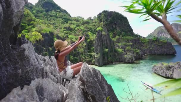 Woman Sitting On Limestone Rocks Taking Photo With Smartphone — Vídeo de stock