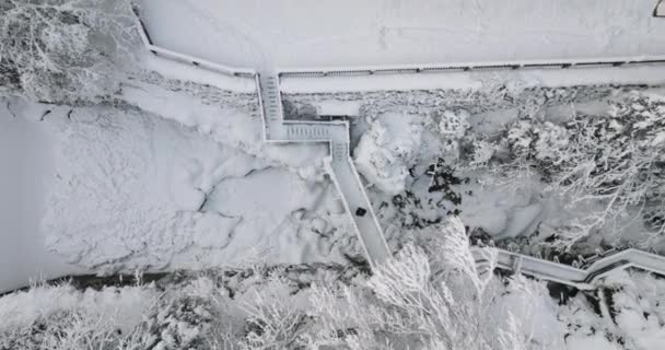 Drone da pessoa que anda sobre a ponte coberta de neve no vale — Vídeo de Stock