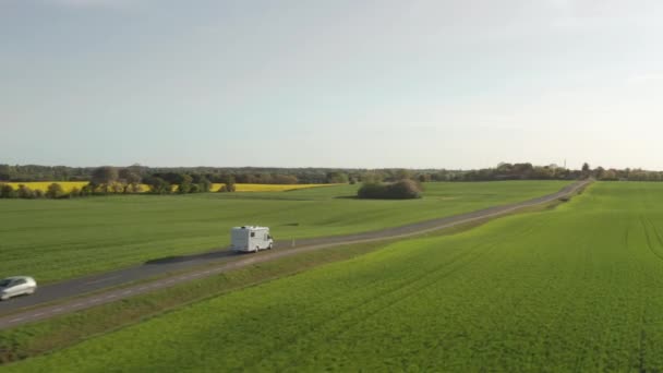 Drone Over Campervan Conducir a lo largo de la carretera a través de campos verdes — Vídeos de Stock