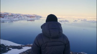 Sahil şeridinde Ilulissat Icefjord, Grönland 'a bakan Sıcak Giysili Adam' ın Orta Çekim Görüntüsü