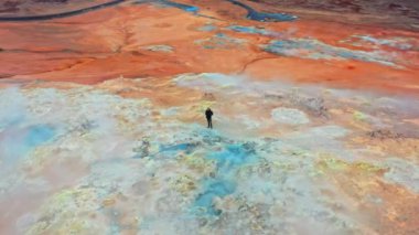 Myvatn Gölü yakınlarındaki Hver Jeotermal Bölgesi 'nde Buharlı Fümerollerin Önünde Duran Bir Adamın Hava Görüntüsü. Geniş Panoramik Yörünge Görüntüsü.