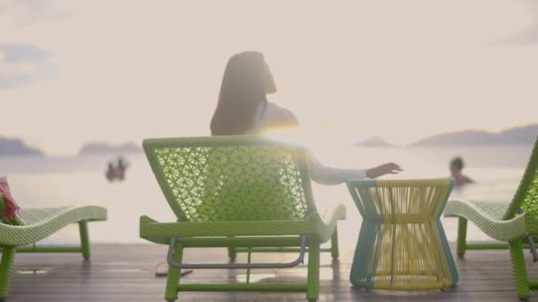 Woman Dark Hairs Sitting Green Lounger Enjoys View Coming Sunset — Stock Video