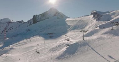 Kışın Kitzsteinhorn Dağı üzerinde kayakçılarla ve kablo arabalarla geniş insansız hava aracı uçuşu, yüksek Tauern Sıradağları, Orta Doğu Alpleri, Avusturya