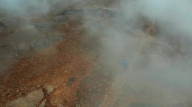 Myvatn Gölü yakınlarındaki Buharlı Hver Jeotermal Bölgesi 'nin hava görüntüsü. İzlanda. Geniş açılı panoramik çekim. Adam Turist Dolaşıyor. Yüksek açılı atış. Drone Buharın Üzerinde Uçuyor ve Turisti İzliyor