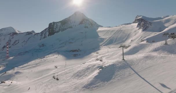 奥地利中东部阿尔卑斯山高陶恩山脉Kitzsteinhorn山滑雪场冬季宽无人机与滑雪者和缆车飞行 — 图库视频影像