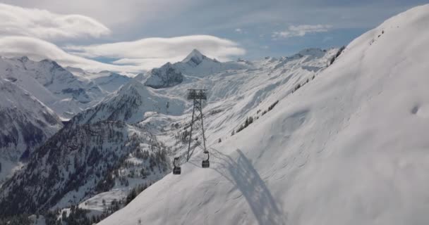 奥地利中东部阿尔卑斯山高陶恩山脉基茨廷角山上 宽缓运动的无人机在冬季驾驶缆车飞行 — 图库视频影像