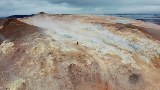 湖Myvatnの近くのHverir地熱地帯での赤い山の火星の形成についての人の空中ビュー パノラマワイドティルトショット カメラのズームイン — ストック動画