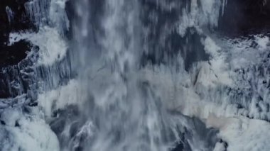 Gufufoss Şelalesi 'nin havadan görünüşü, İzlanda. Adam Şelalenin Tepesinde Duruyor. Çarpıcı Panoramik Kış Manzarası. Geniş eksenli atış. Kamera Şelale boyunca ilerler.