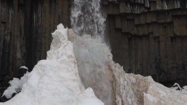 Svartifoss Şelalesi ve bazalt lav sütunları destansı manzarası. Vatnajokull Ulusal Parkı, İzlanda. Çok yakın çekim, ağır çekim statik çekim. Buza Düşen Su Akıyor.