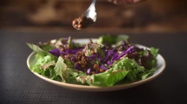 Şefin Eli, fasulyeli salata servis ediyor. Sağlıklı gıda konsepti. Bokeh Çekimine Yakınlaş