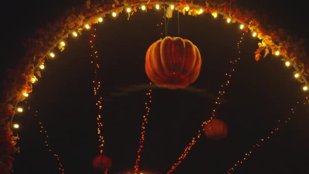 遊園地の路地でハロウィンカボチャの提灯夜に輝く ハロウィンの装飾 神秘的な夜の雰囲気 手を上に傾けるショット — ストック動画
