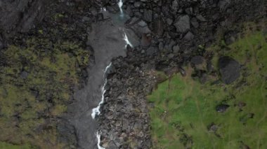 Faroe Adaları 'ndaki Fossa Şelalesinin Havası. Vahşi Rocky Hillside 'da Görkemli Şelale. Cascades 'in tepesinde adamlar var. Üst Aşağı Çekim Kamerası İlerliyor